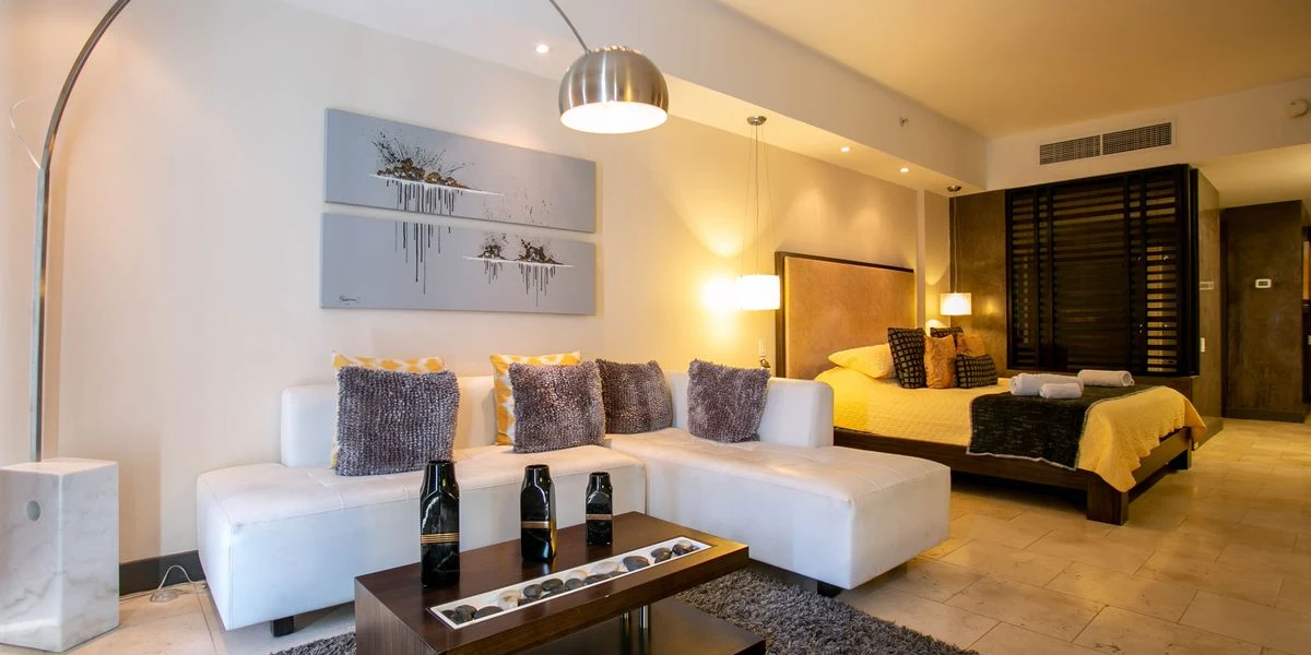 Suite de acceso exclusivo con amplia sala lounge, mobiliario contemporáneo y dormitorio principal